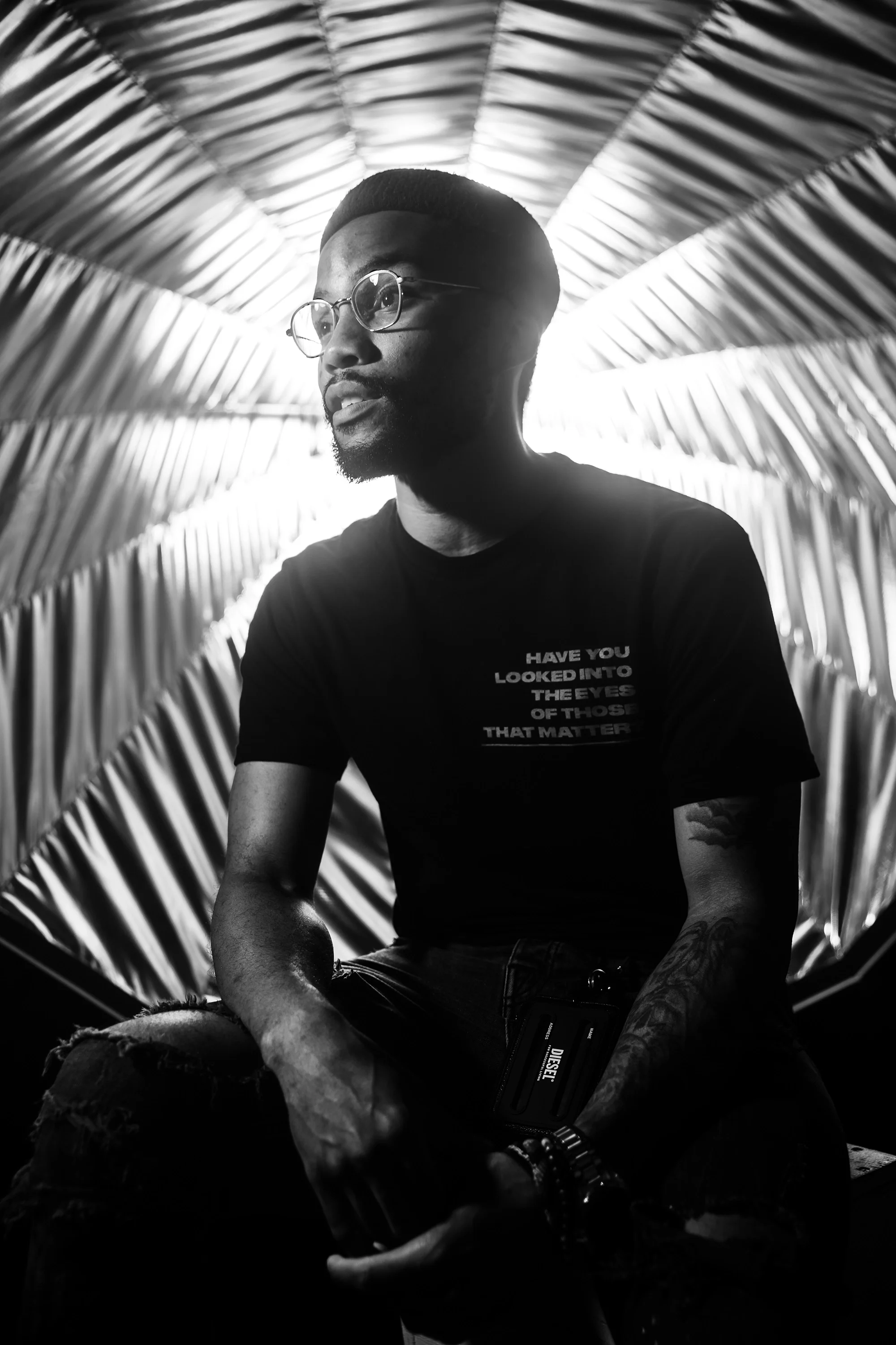 Black and white photo of Mansa Johnson in a black t-shirt, set against a textured background