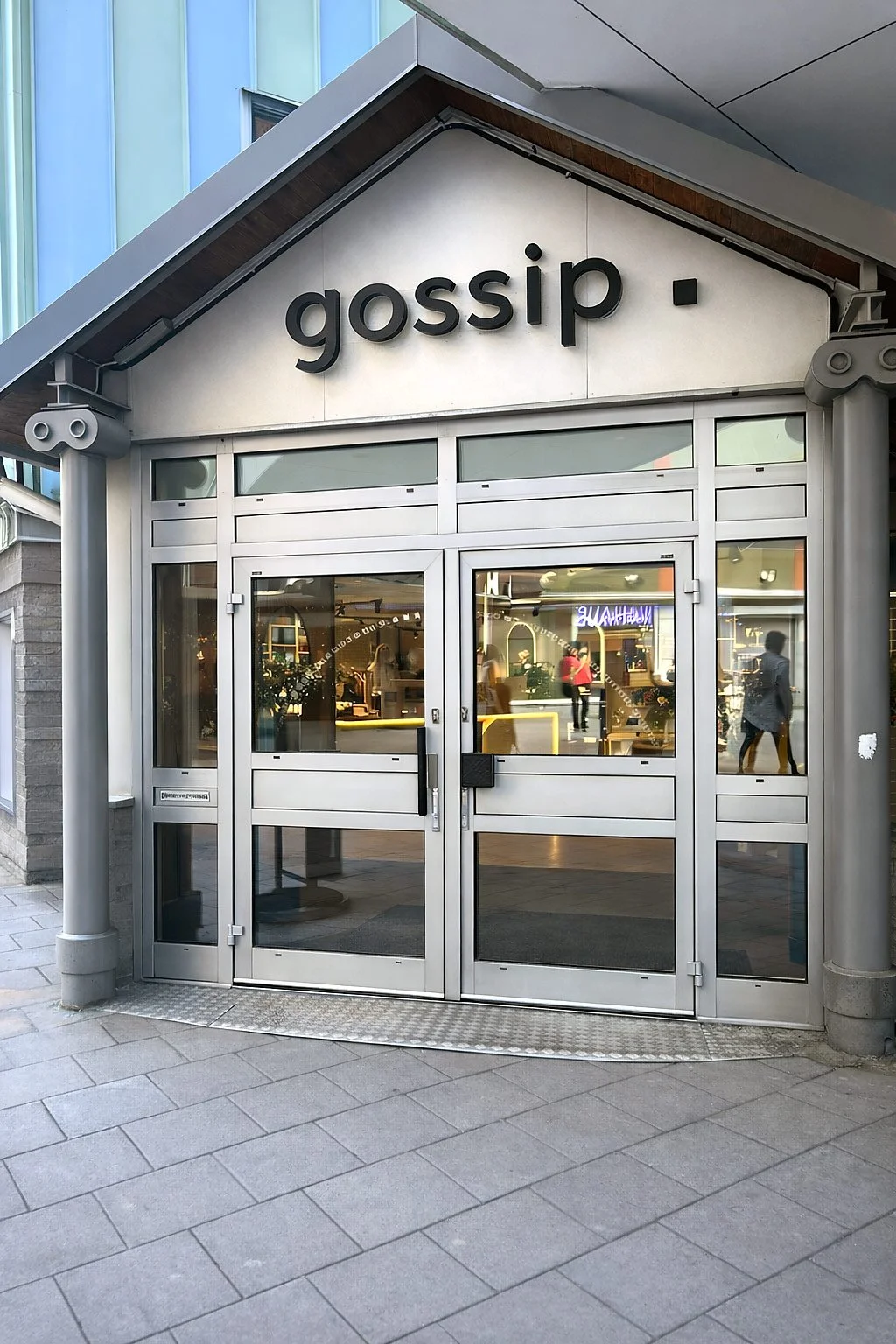 Fasadskylt med texten Gossip ovanför butikentré i galleria i Luleå, Norrbotten