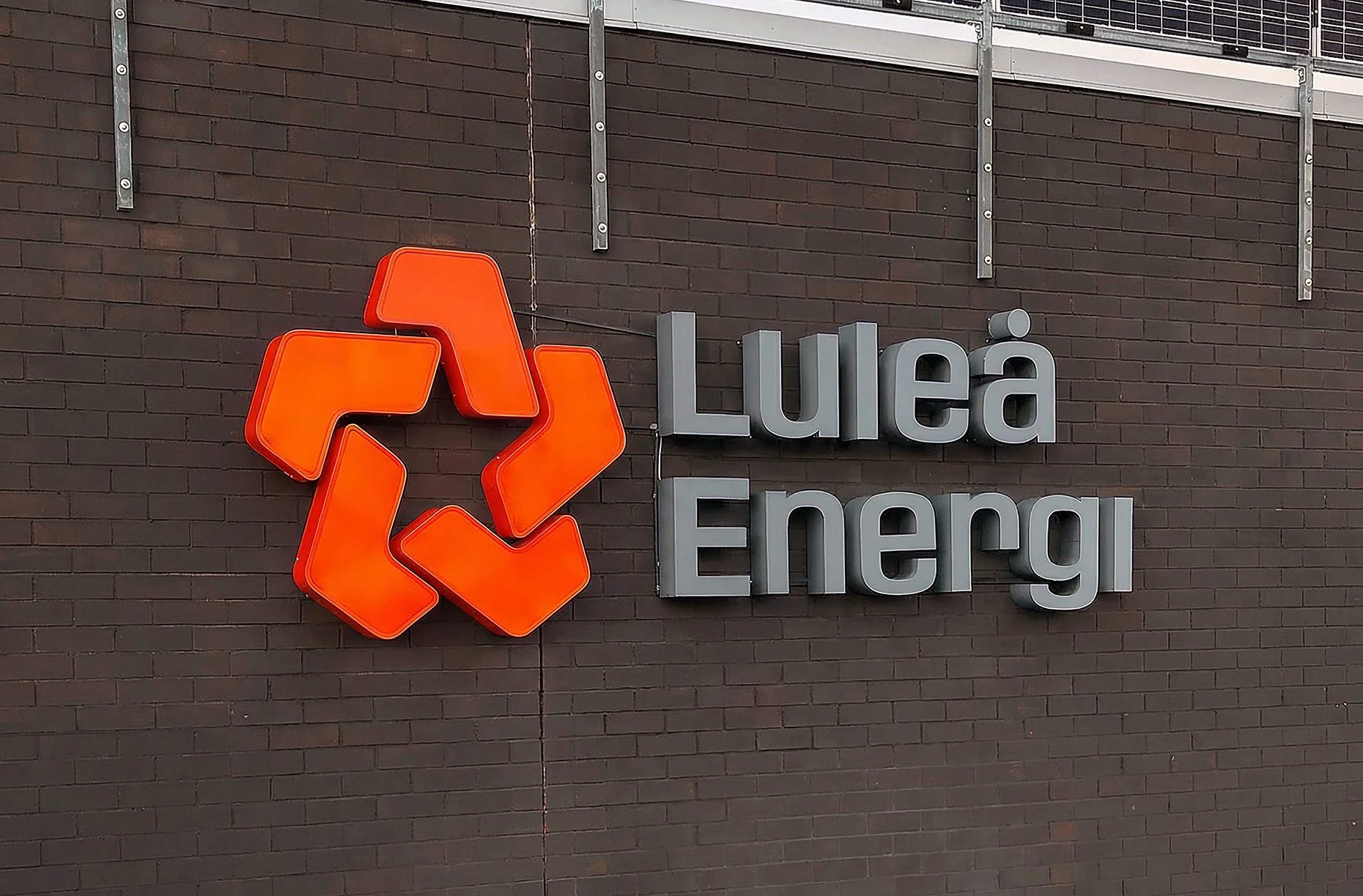 Fasadskylt med Luleå Energis logotyp på tegelvägg i Luleå, Norrbotten