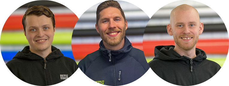SkyltVision's team, tre personer, alla i sportjackor, står bredvid varandra och ler, med en färgglad bakgrund.