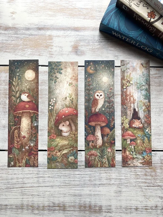Colorful notebooks with black intricate tree designs and the words Wool & Wisdom, placed on a light wooden surface with a pen on top.