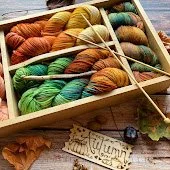 Image of a wooden box filled with colorful skeins of yarn.