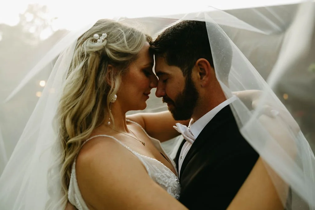 Bride and groom share an intimate portrait beneath the bride’s veil during an Atlanta wedding designed by Port Town Collective