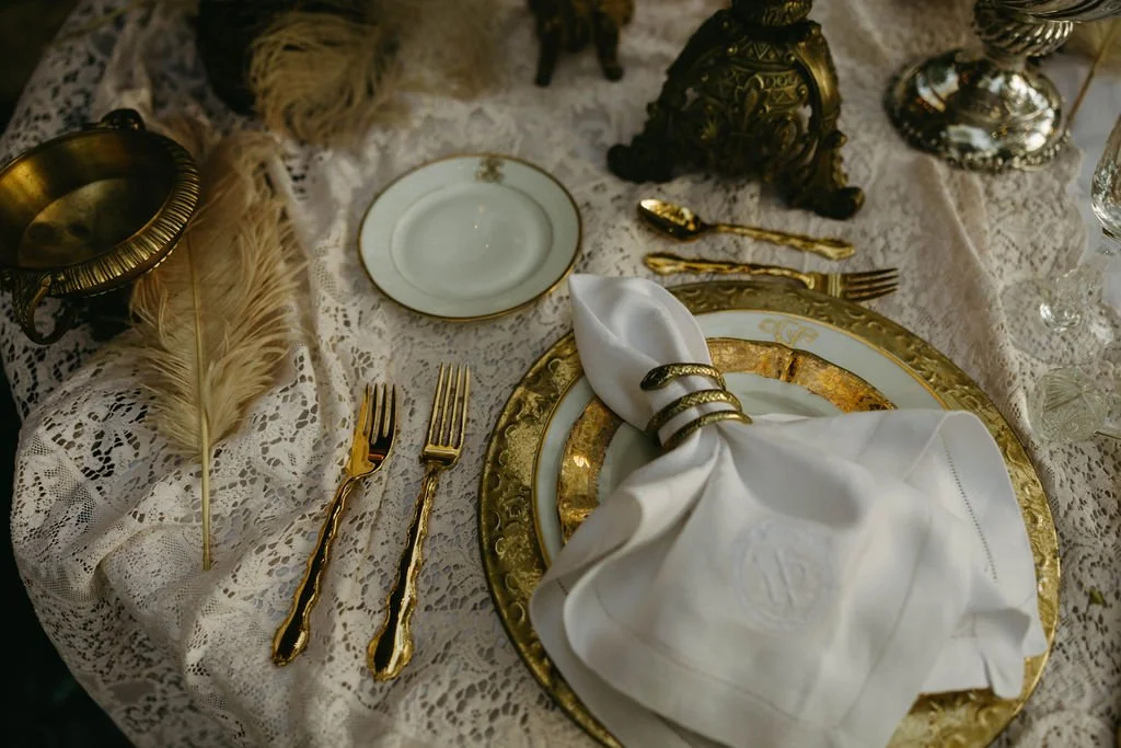 Editorial close-up of a Gilded Age-inspired wedding table featuring layered textures, candlelight, florals, and antique details at an Atlanta wedding.