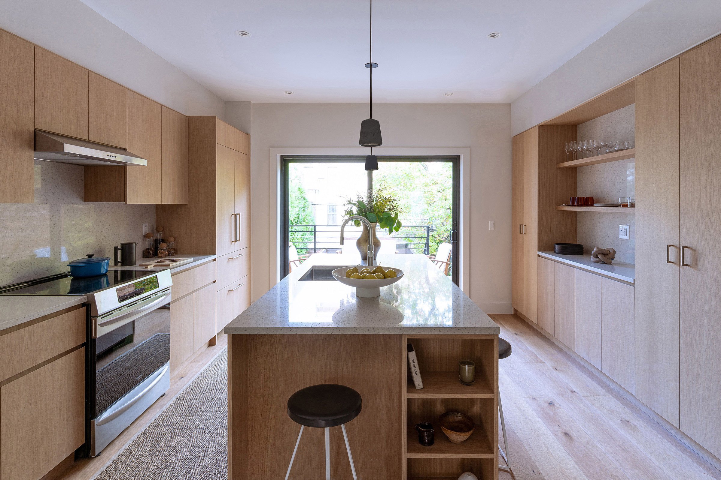 Modern kitchen with wooden cabinets, quartz island, and stainless steel appliances