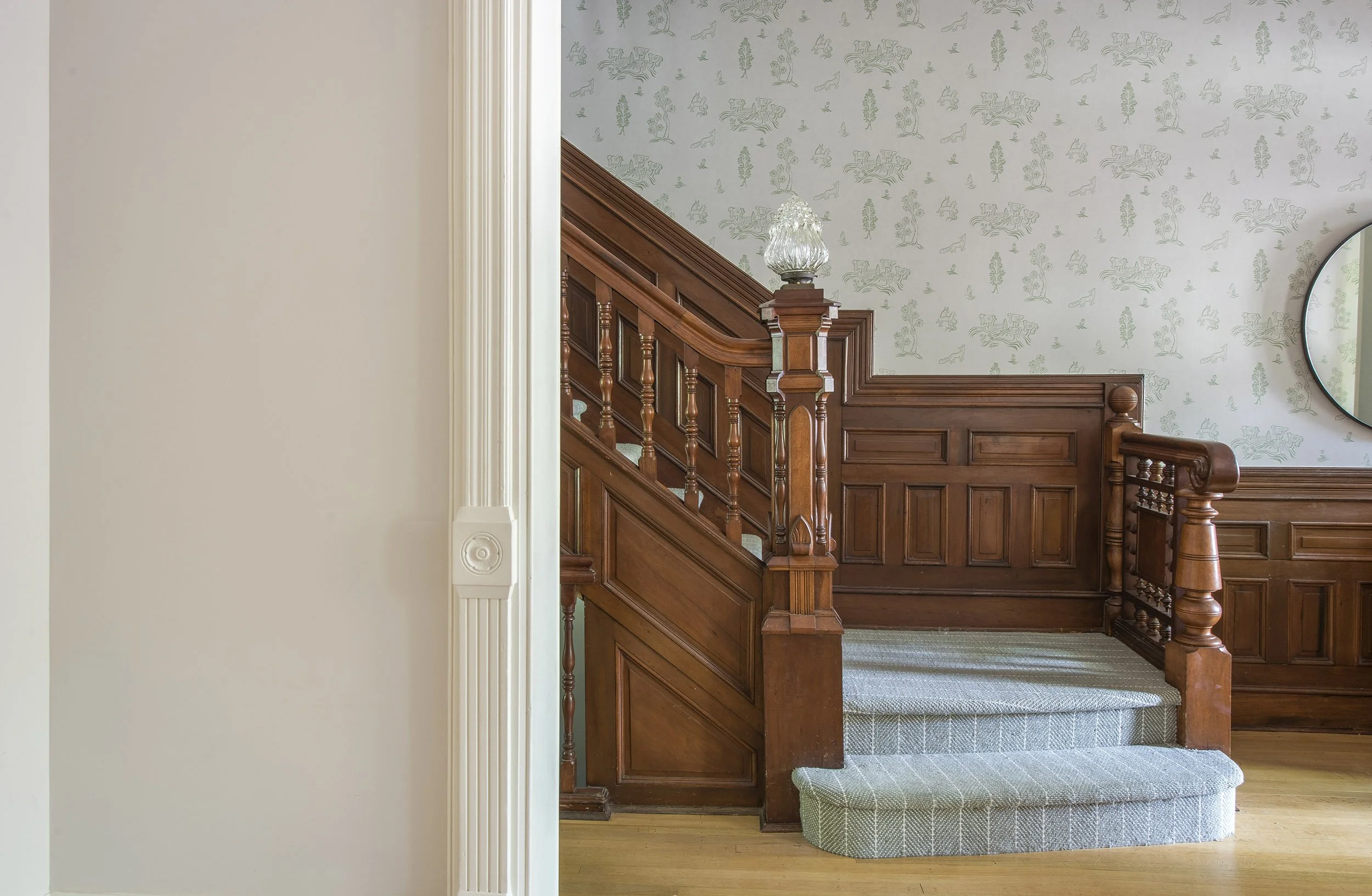 Interior view of a vintage staircase with wood railing and floral wallpaper - at a Park Slope Brooklyn brownstone project