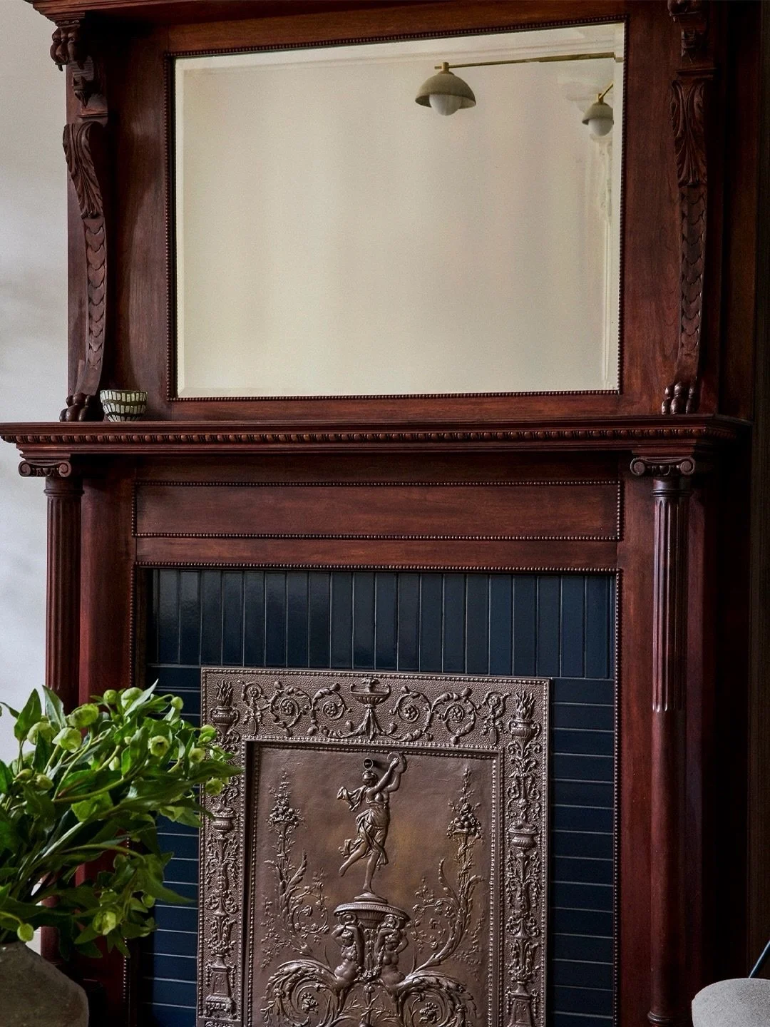 Originally discovered at the rear of the parlor level, the home&rsquo;s 1897 wood mantel was carefully relocated, meticulously restored, and reinstalled as a focal point in the renovated living room. A surround of deep blue tiles by @heathceramics ad