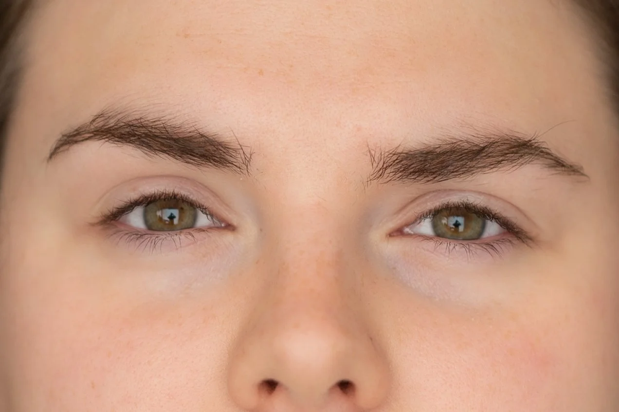 Vue rapprochée du visage d'une femme avec des sourcils épais et des yeux verts. avant après d'un recourbement de cils et brow lift.