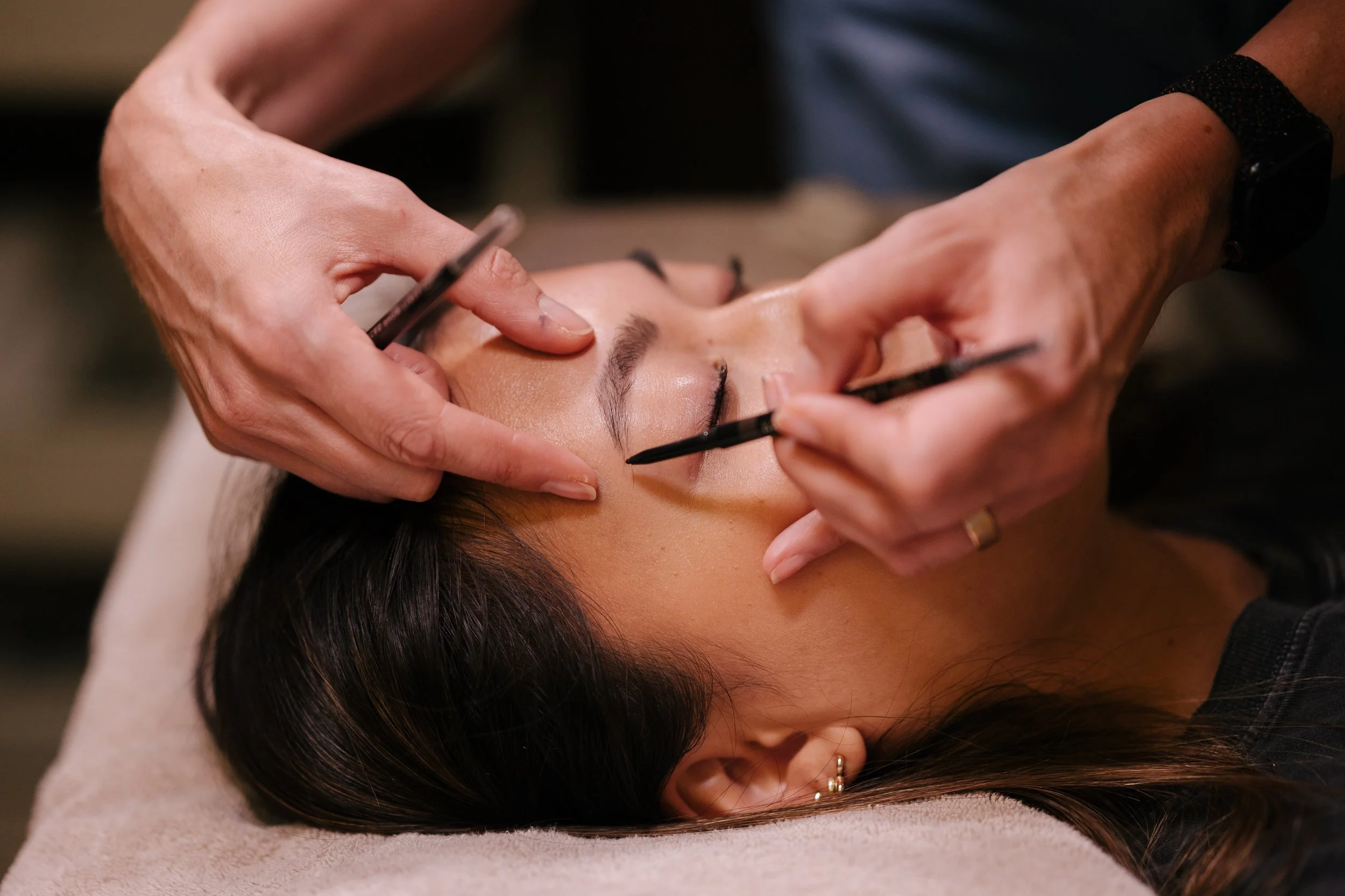 Une femme reçoit une  teinture des sourcils par une technicienne dans un salon de beauté. Maquillage et restructuration des sourcils