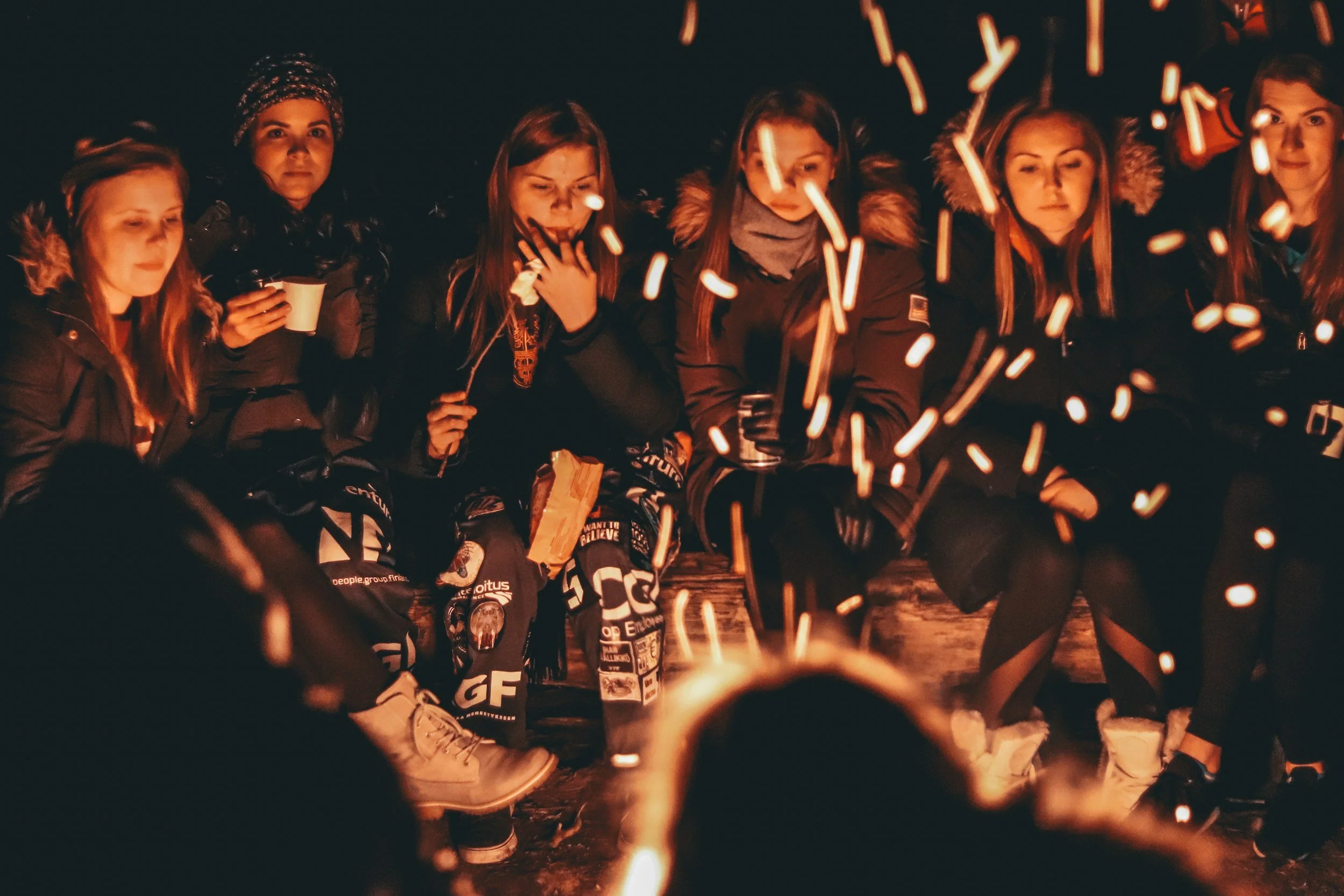 women who have experienced a miscarriage around a campfire together