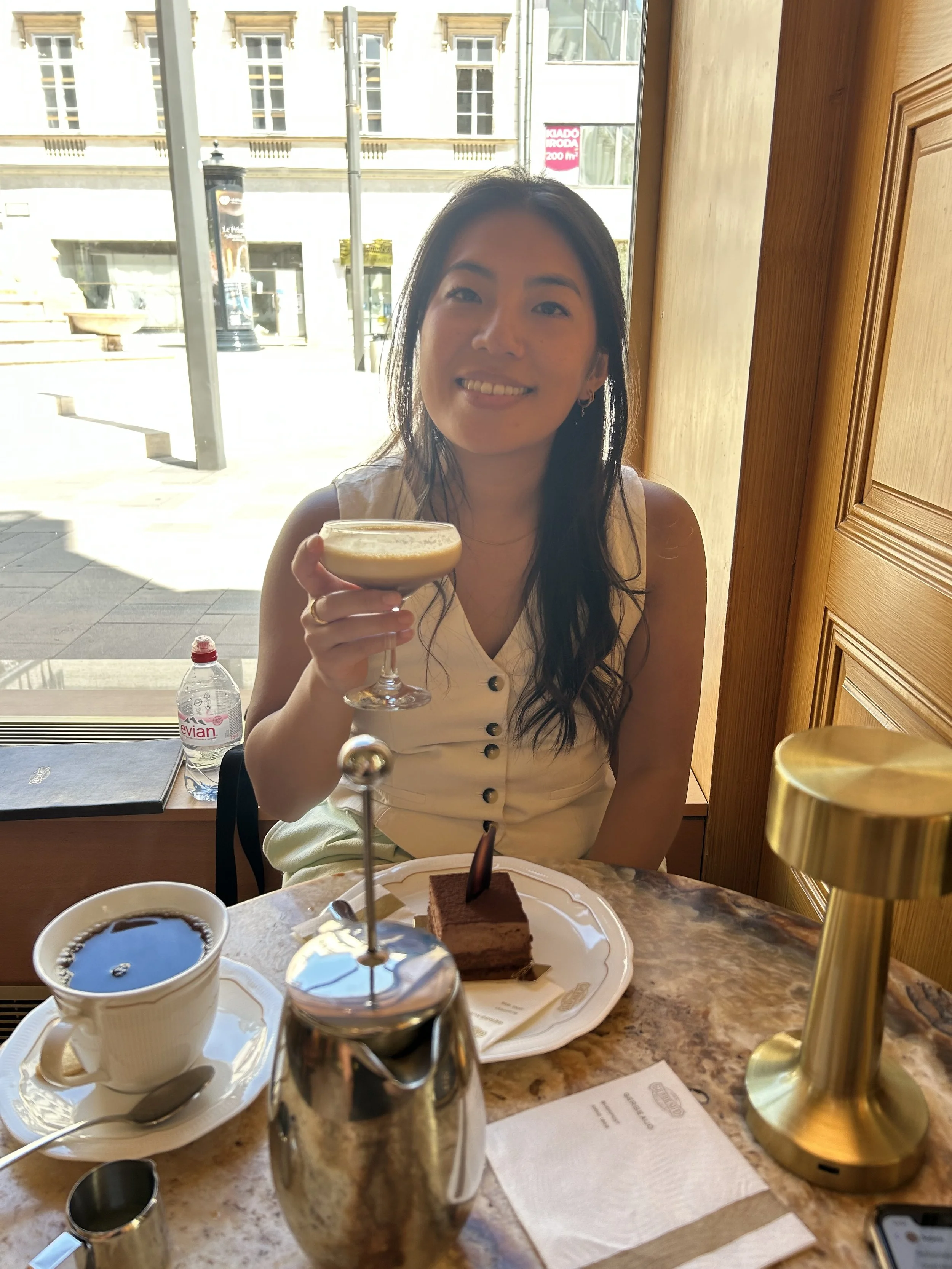 A person wearing a straw hat facing the ocean.