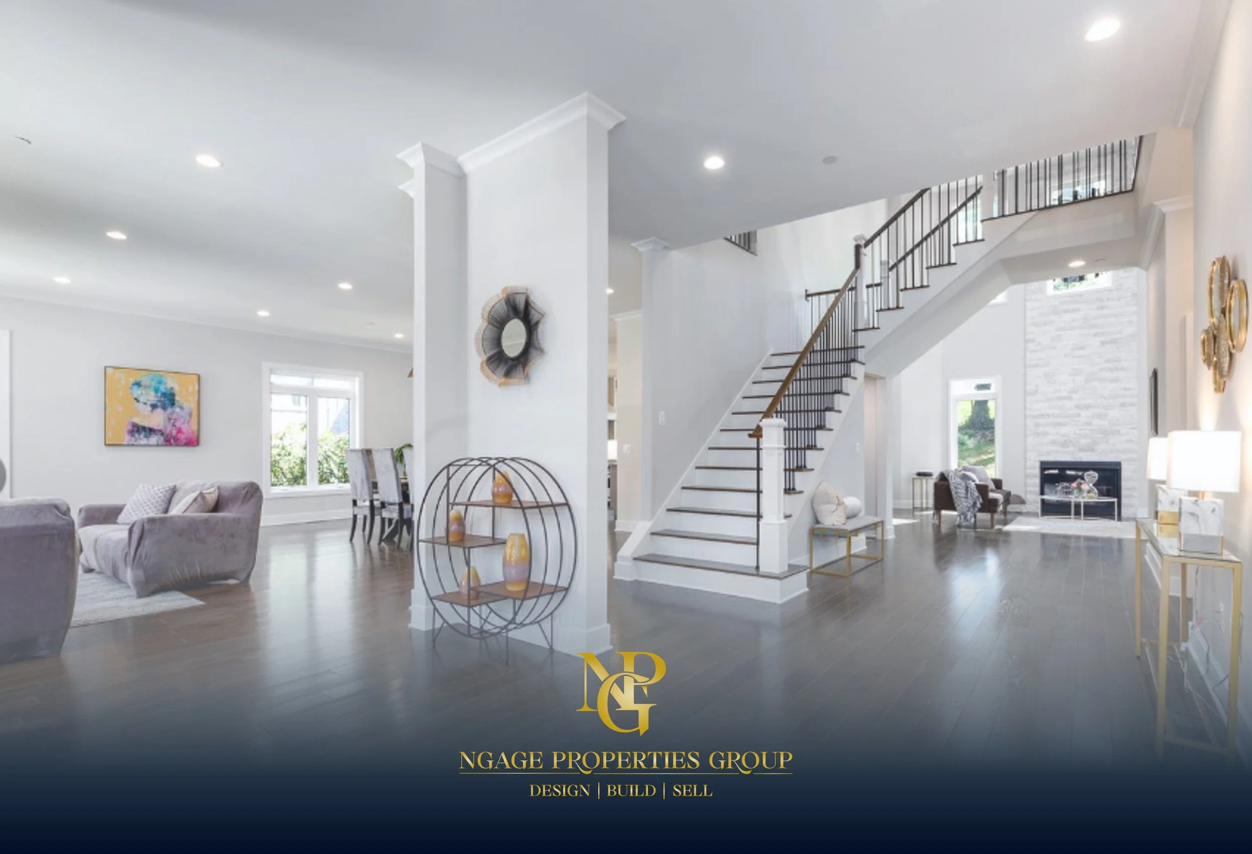 Living room with white walls, a staircase with wooden steps and black railing, a sitting area with chairs and a fireplace, decorated with modern art and gold accents.