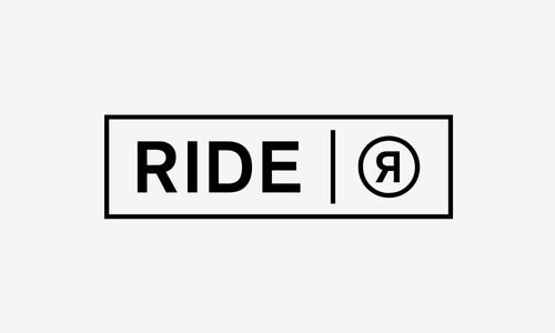 Logo avec le texte "RIDE" à gauche, un séparateur vertical, et un cercle contenant le symbole ou la lettre "R" à droite.