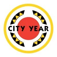 A circular logo with a yellow border, a red circle in the center, and black and yellow arrow designs. The words 'CITY Y EAR' are written across the red circle.