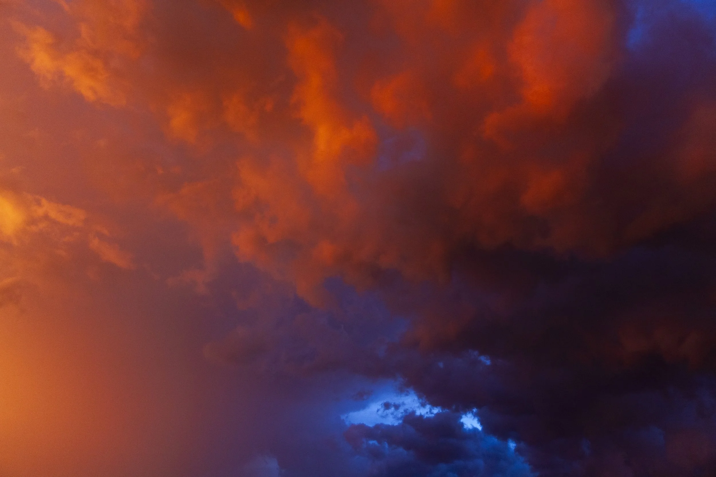 Vivid orange and blue clouds in a sunset sky.