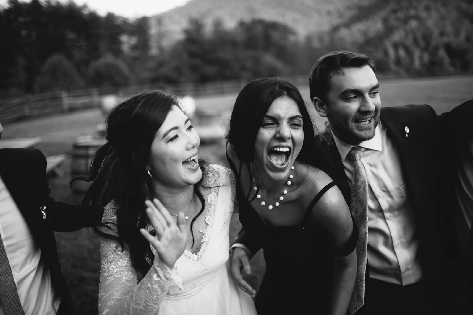 Black and white photo of joyful people at a social gathering outdoors, smiling and laughing.