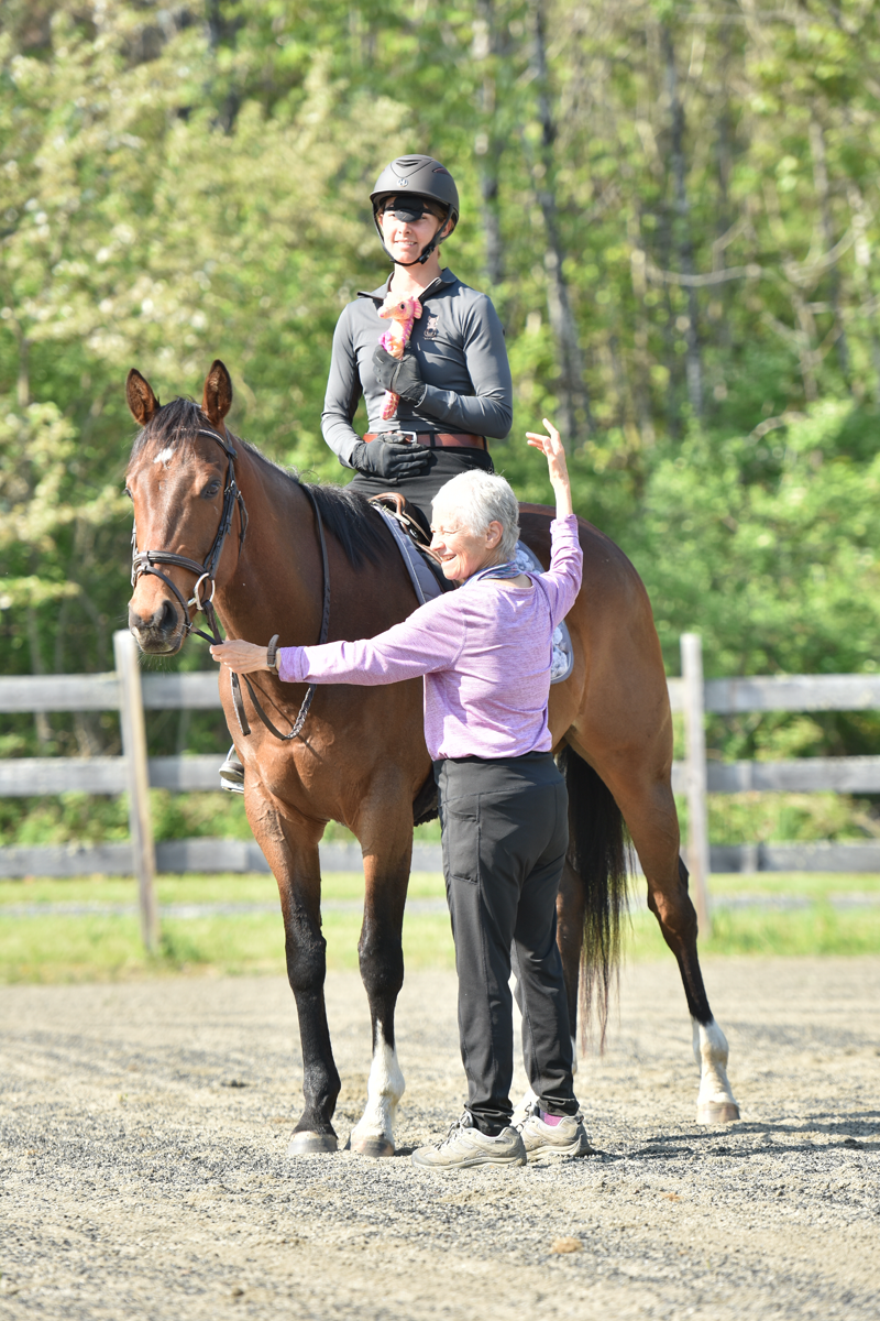 Instructor Joyce Kramer showing horseback rider how to use core muscles in front of body.
