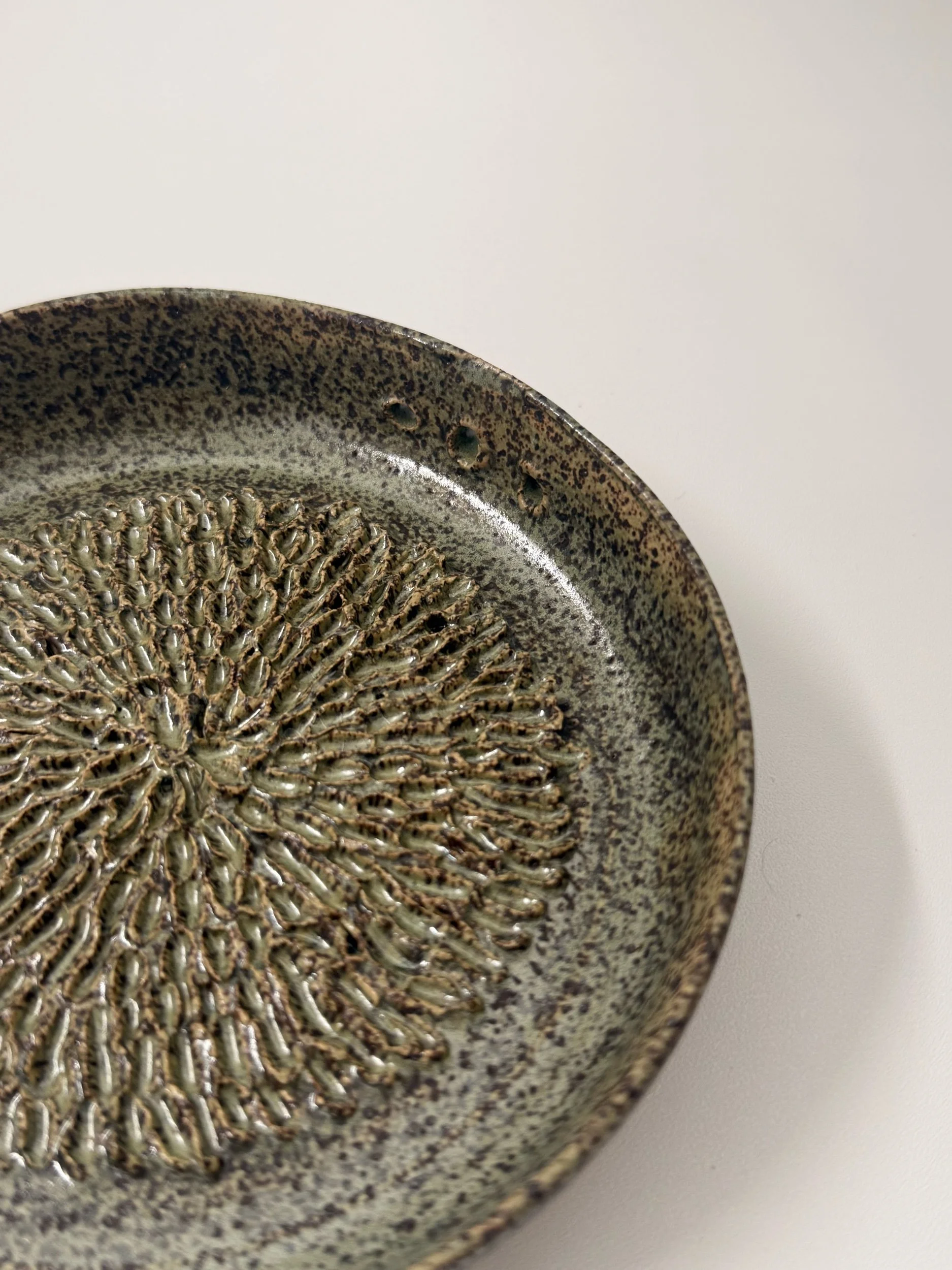 A sage green speckled herb grater