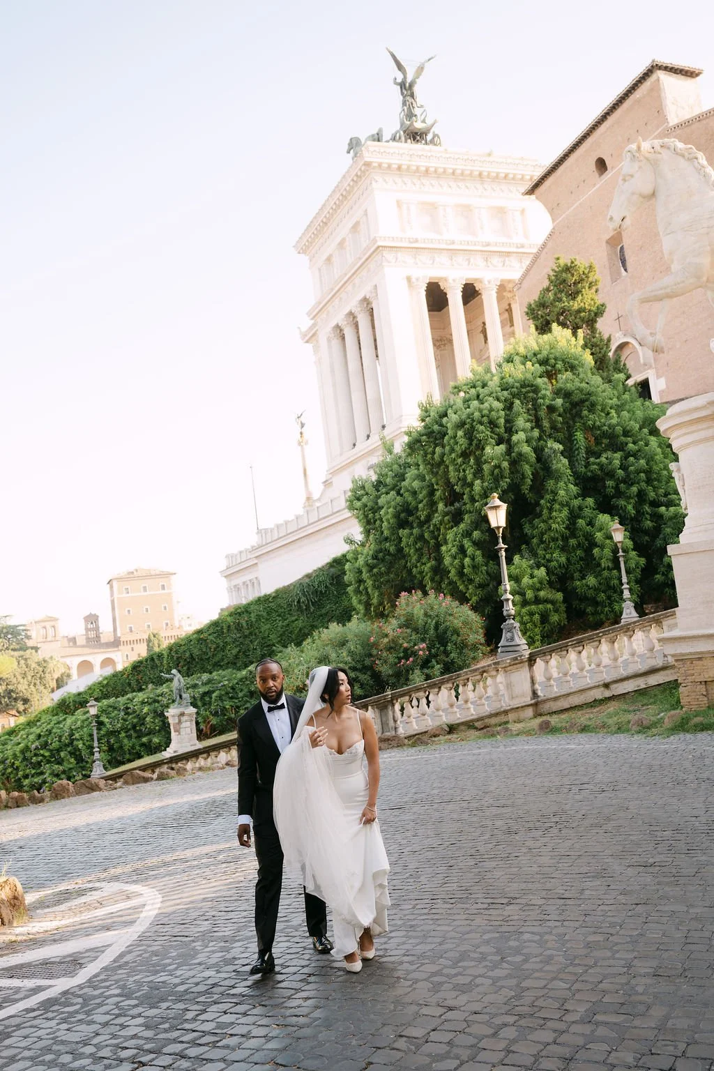 sarapaolucci-bride-and-groom-walking-with-viittoriano-on-the-background.jpg