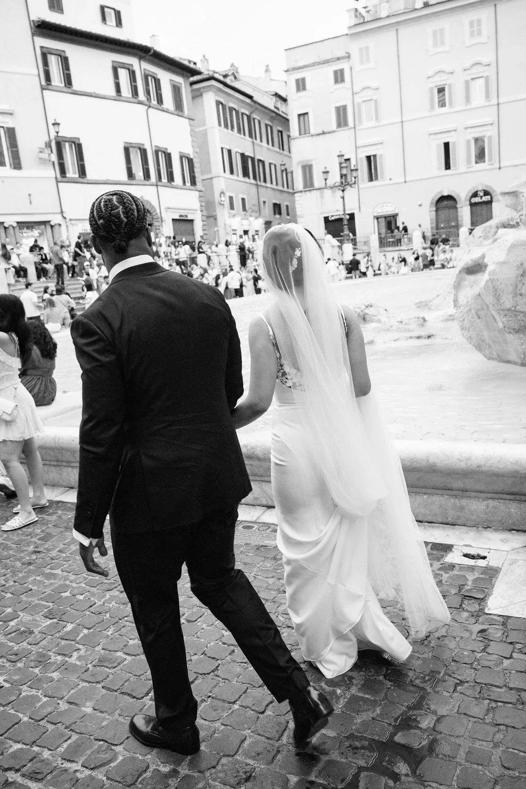sarapaolucci-bride-and-groom-walking-along-trevi-fountain-in-rome.jpg