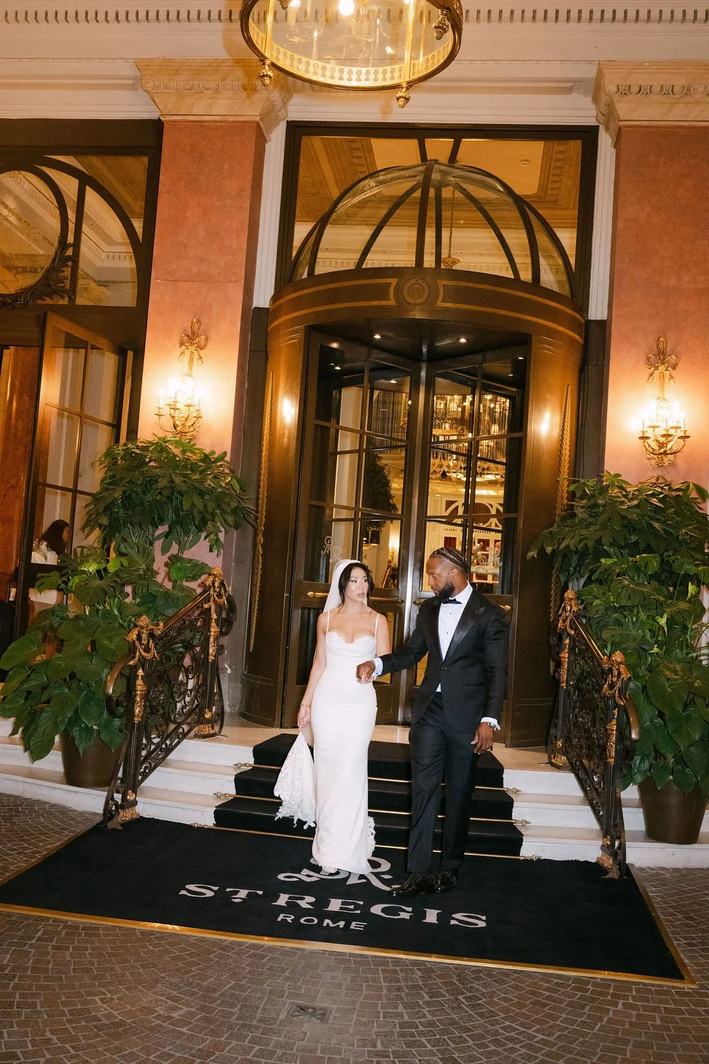sarapaolucci-bride-and-groom-walking-out-of-stregis-hotel-in-rome.jpg