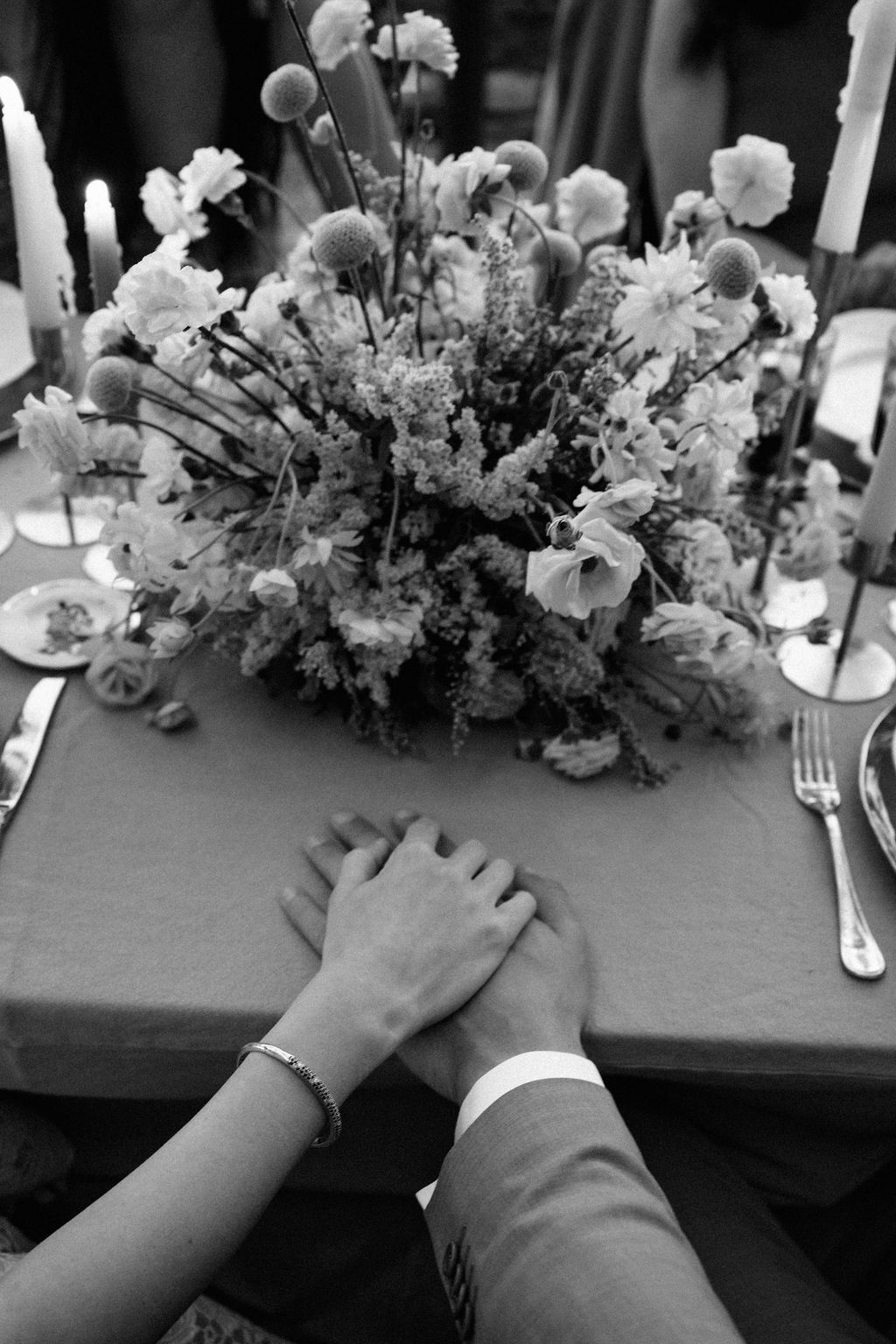sarapaolucci-bride-and-groom-holding-hand-at-dinner-table.jpg