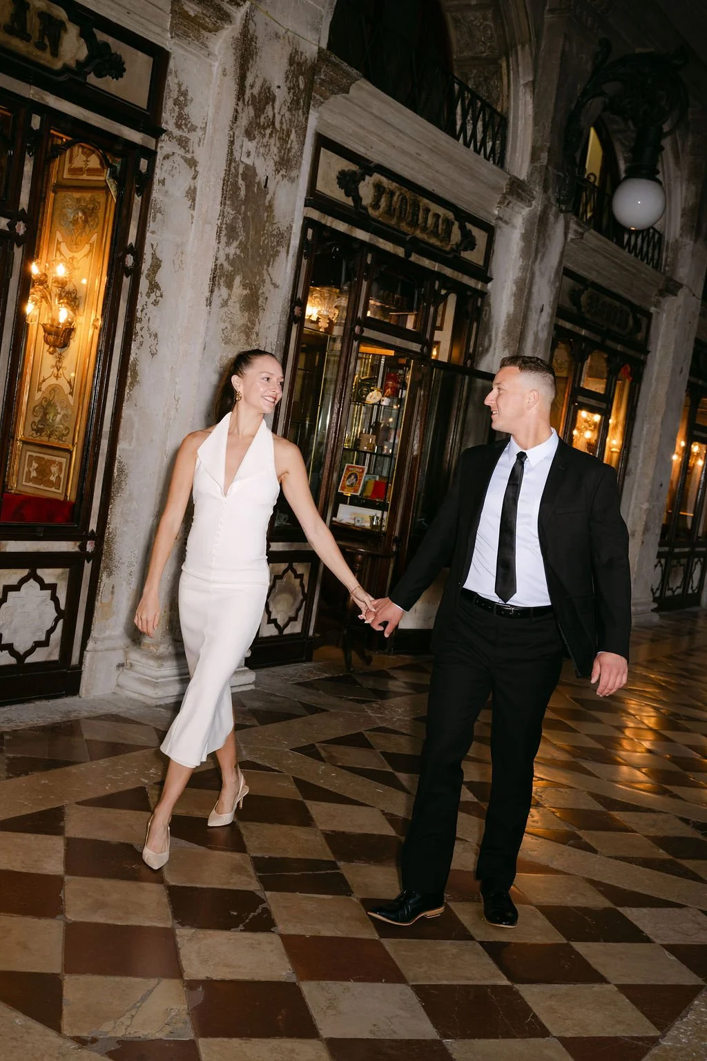 sarapaolucci-bride-and-groom-walking-in-front-of-cafe-florian-in-venice.jpg