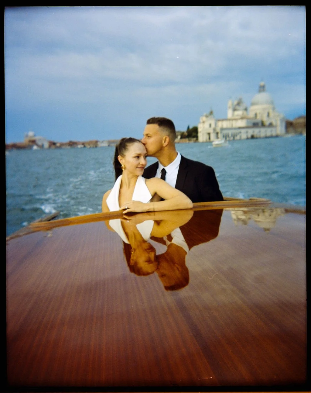 sarapaolucci-film-photo-of-groom-kissing-the-bride-on-a-boat-in-venice.jpg