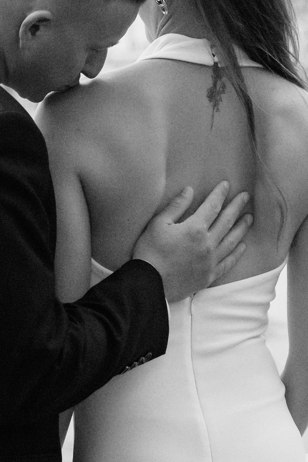 sarapaolucci-close-up-of-groom-kissing-brides-shoulder.jpg