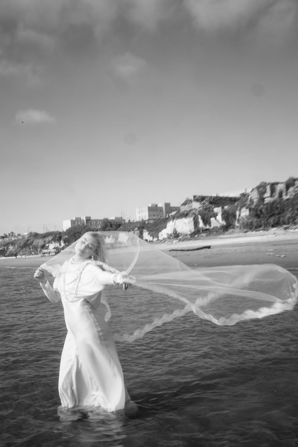 sarapaolucci-bride-portrait-in-the-sea-with-her-veil-flying-in-the-wind.jpg