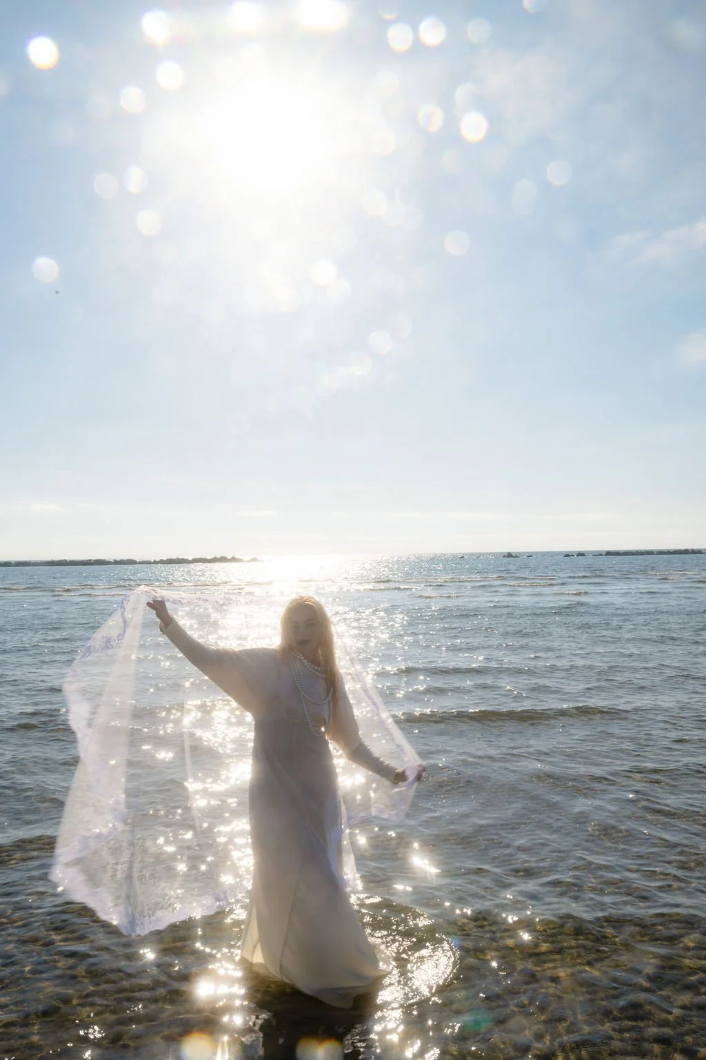 sarapaolucci-bride-playing-with-her-veil-on-the-sea.jpg