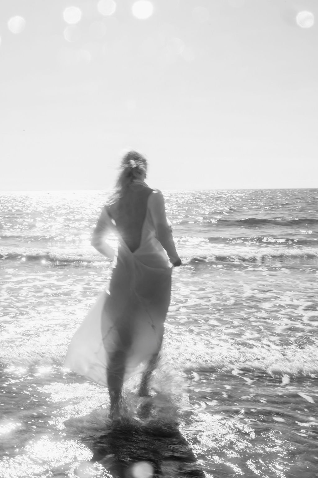 sarapaolucci-black-and-white-photo-of-bride-walking-on-the-sea.jpg