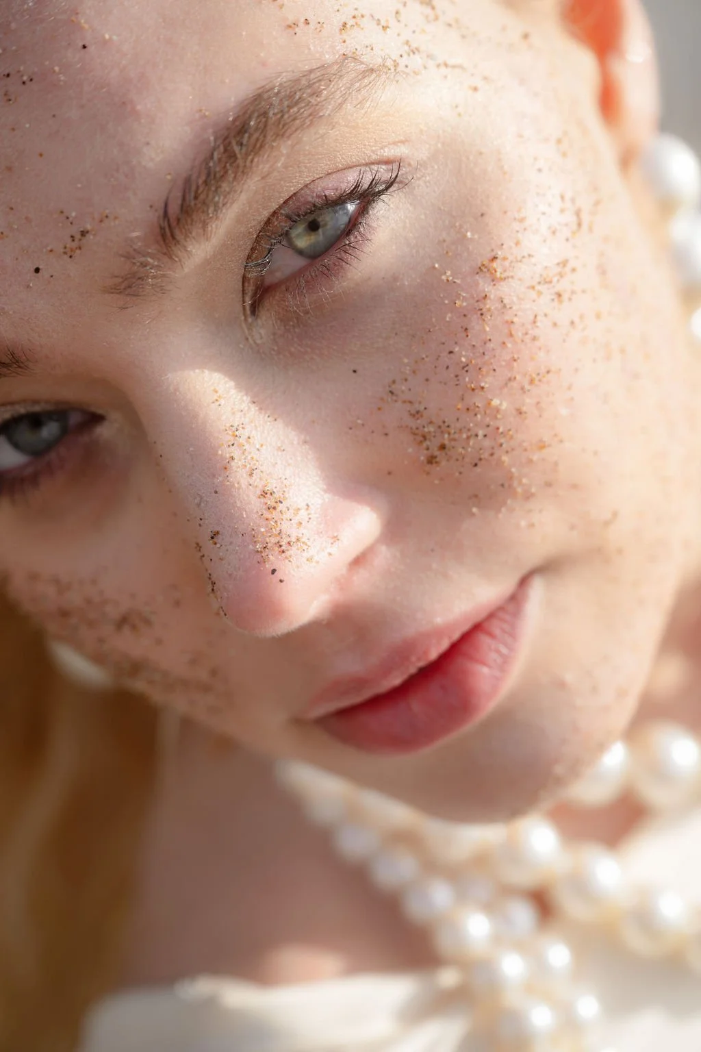 sarapaolucci-close-up-of-bride-cheek-covered-in-sand.jpg