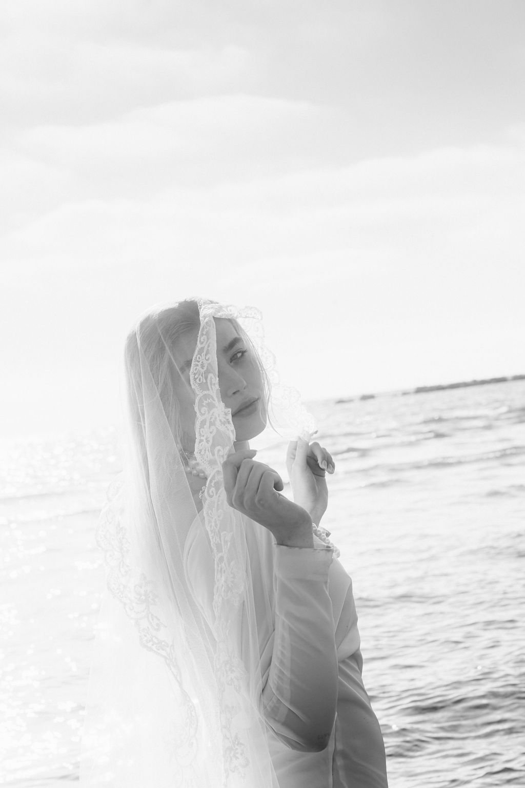 sarapaolucci-bride-portrait-in-black-and-white-touching-her-veil.jpg