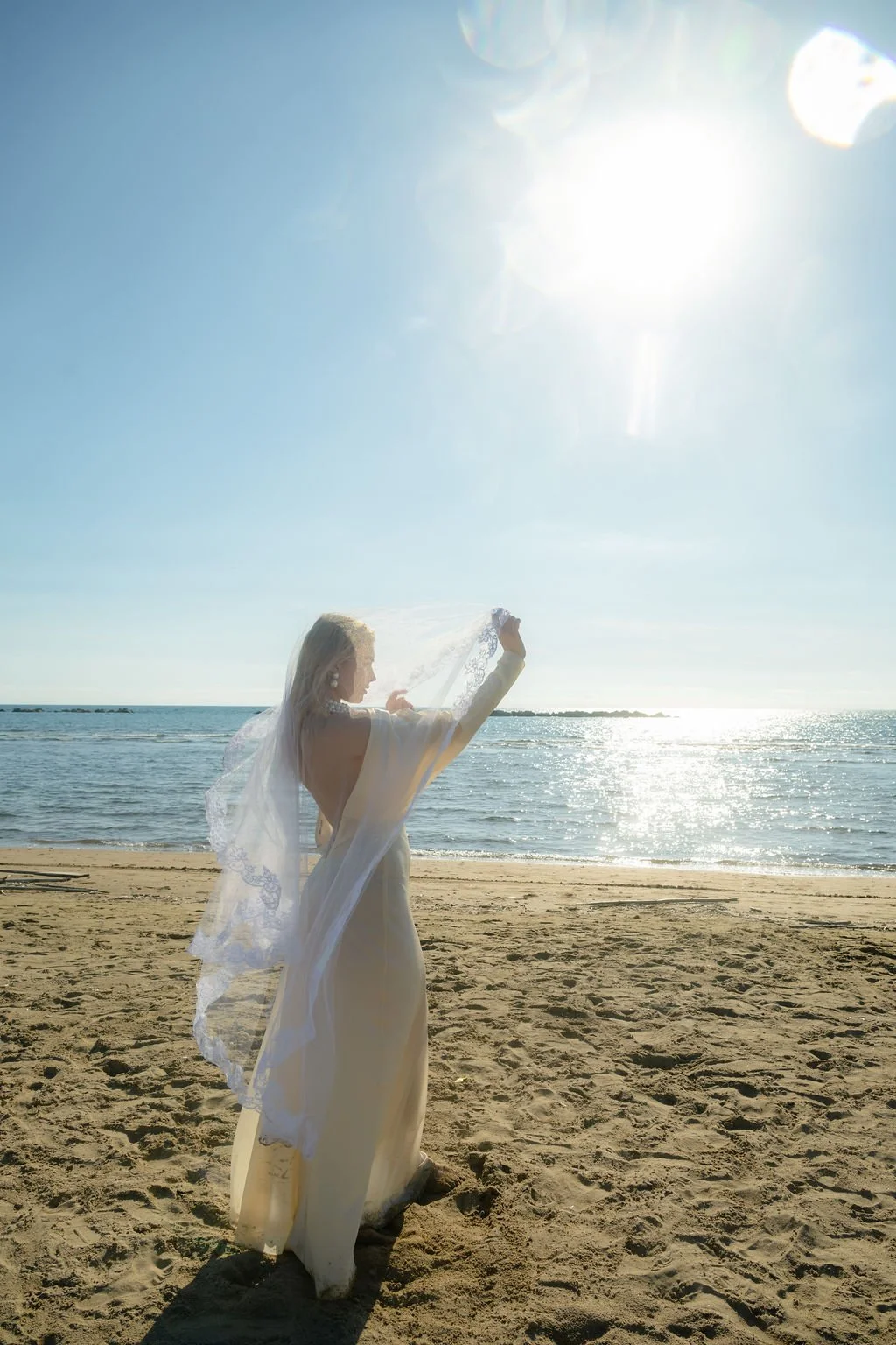 sarapaolucci-bride-playing-with-veil-against-the-sun.jpg