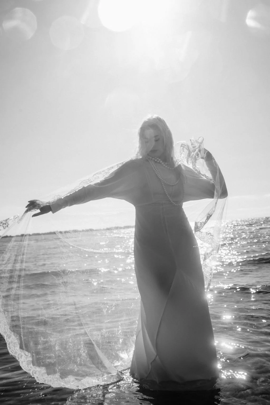 sarapaolucci-bride-playing-with-veil-on-the-seashore.jpg