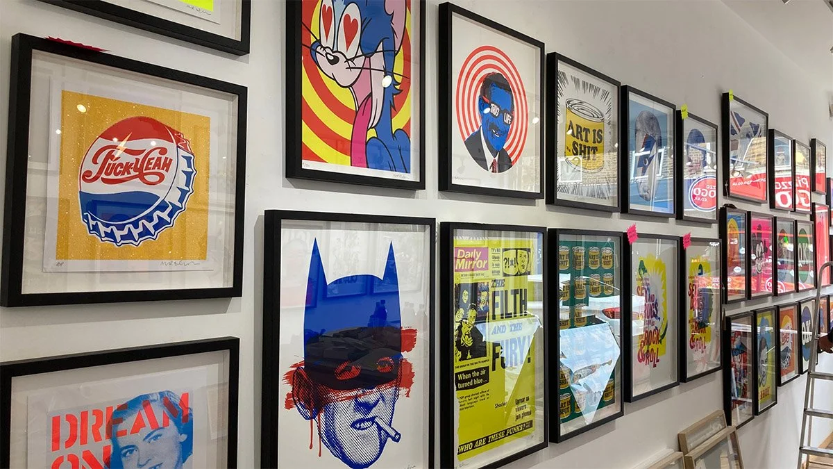 Gallery wall with framed pop art posters featuring colorful and stylized images and text