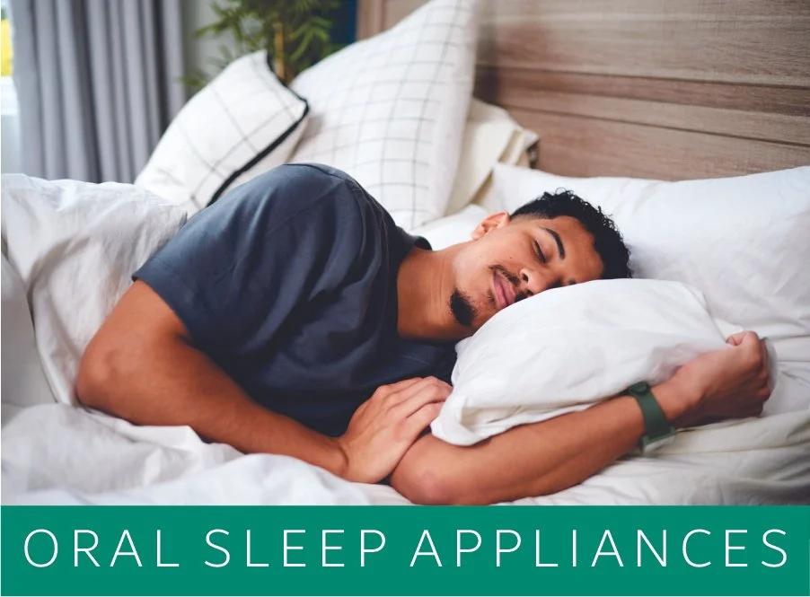 A man sleeping peacefully on a bed with white sheets and pillows, holding a pillow close to his face, in a bedroom setting. Text overlay says "ORAL SLEEP APPLIANCES"