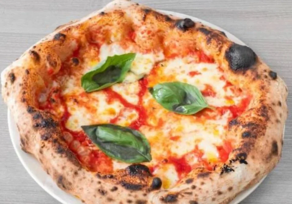 Margherita pizza with melted cheese, tomato sauce, and fresh basil leaves on top