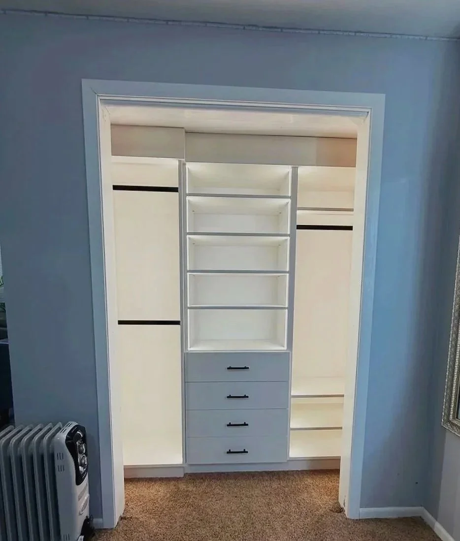 White reach-in closet system with centered drawers and shelving against blue wall