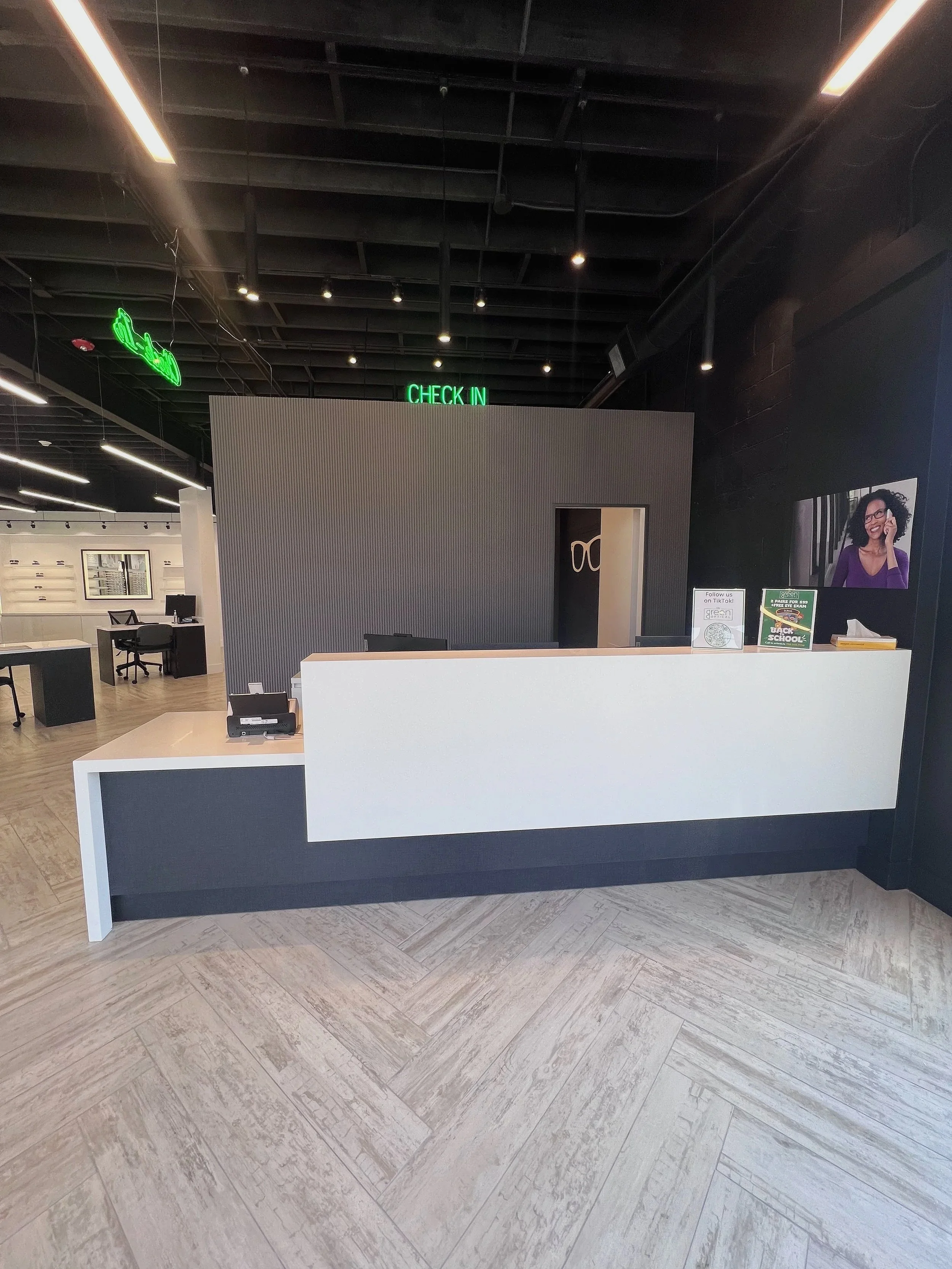 Modern commercial reception desk with black accent wall and Check-In sign