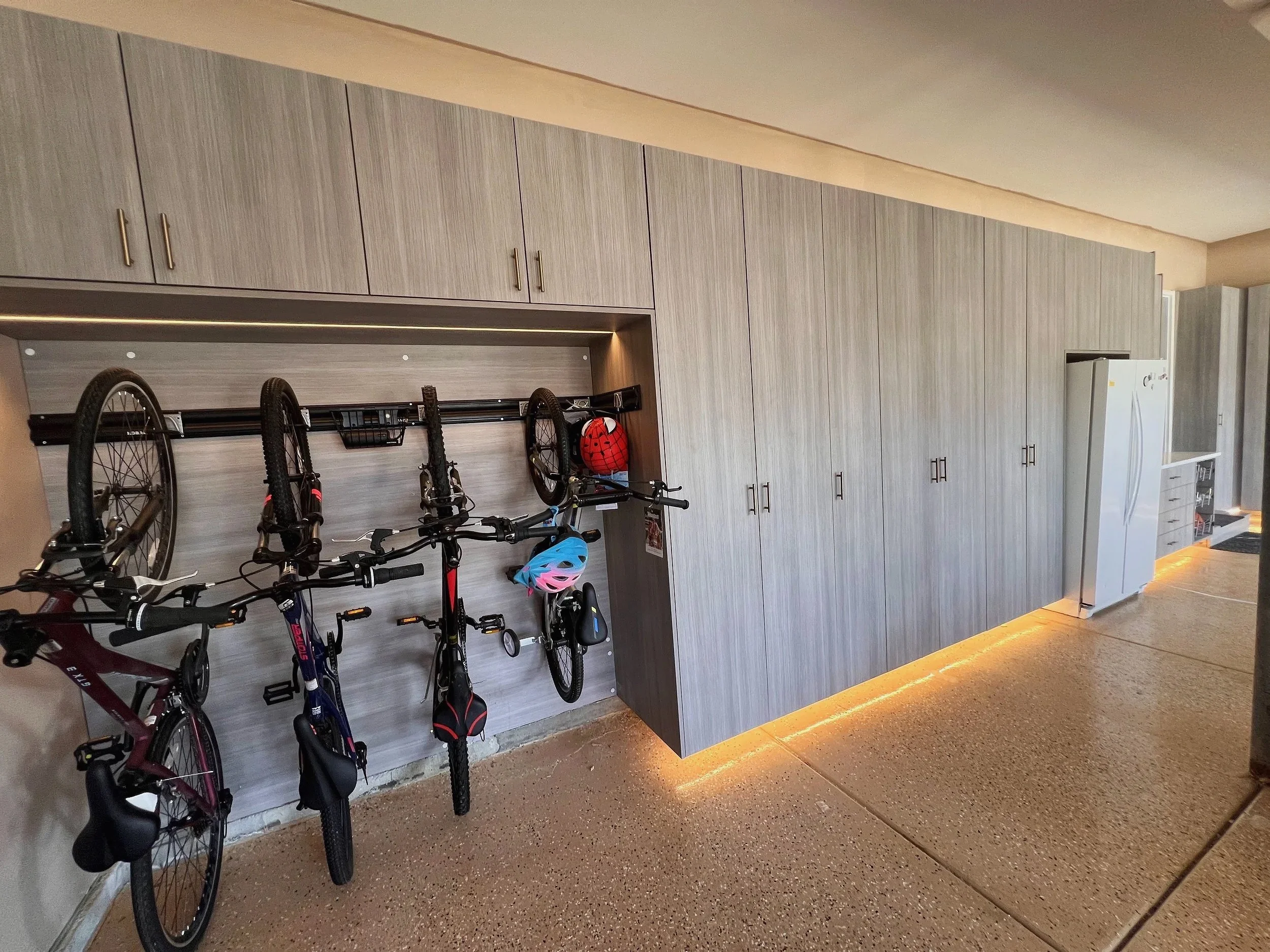 Garage wall system with bike racks and full-height light wood storage cabinets
