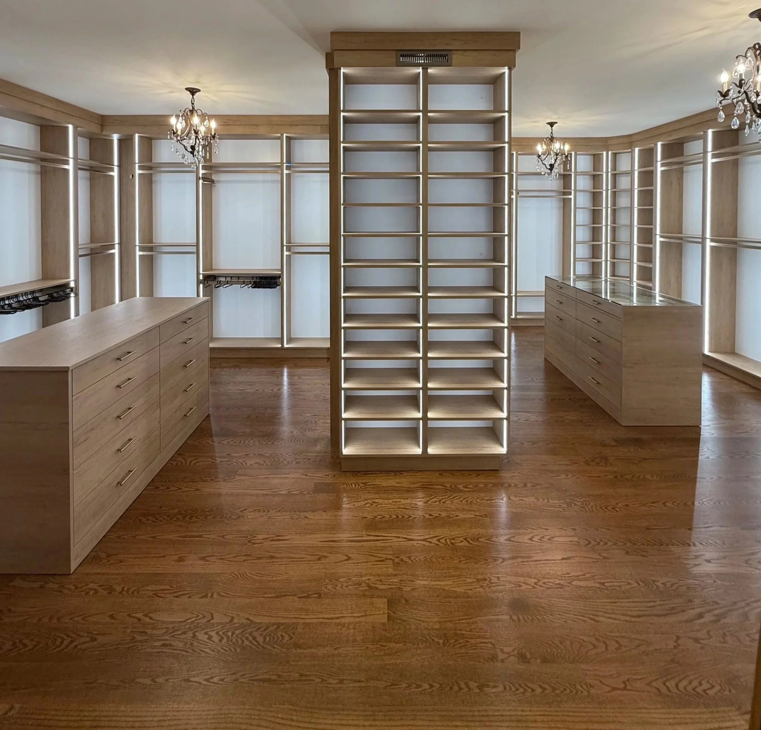 Large wood-tone luxury walk-in custom closet with double islands and LED shelving in Mokena IL