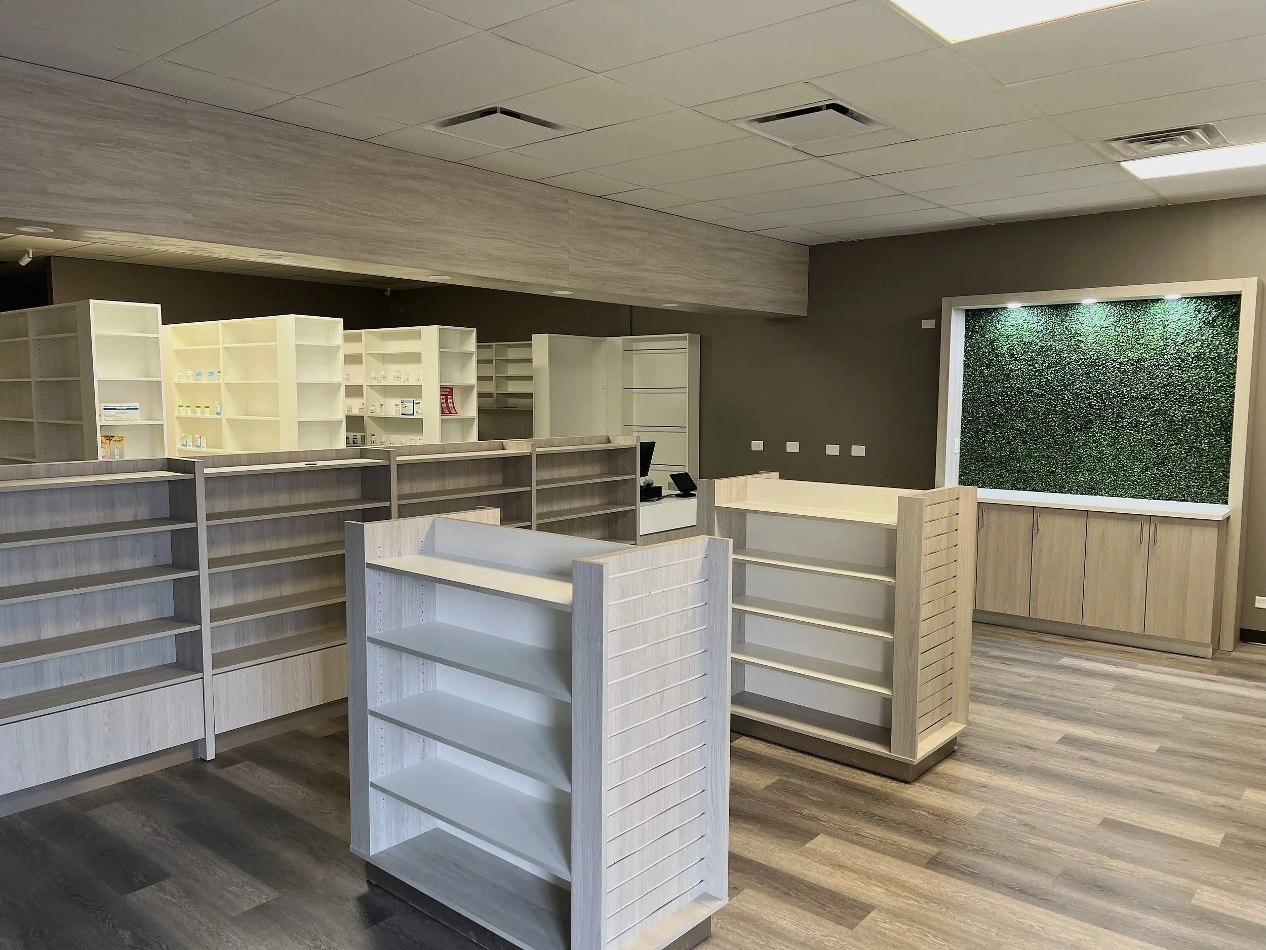 Custom pharmacy shelving and display fixtures in light wood finish, Chicago area