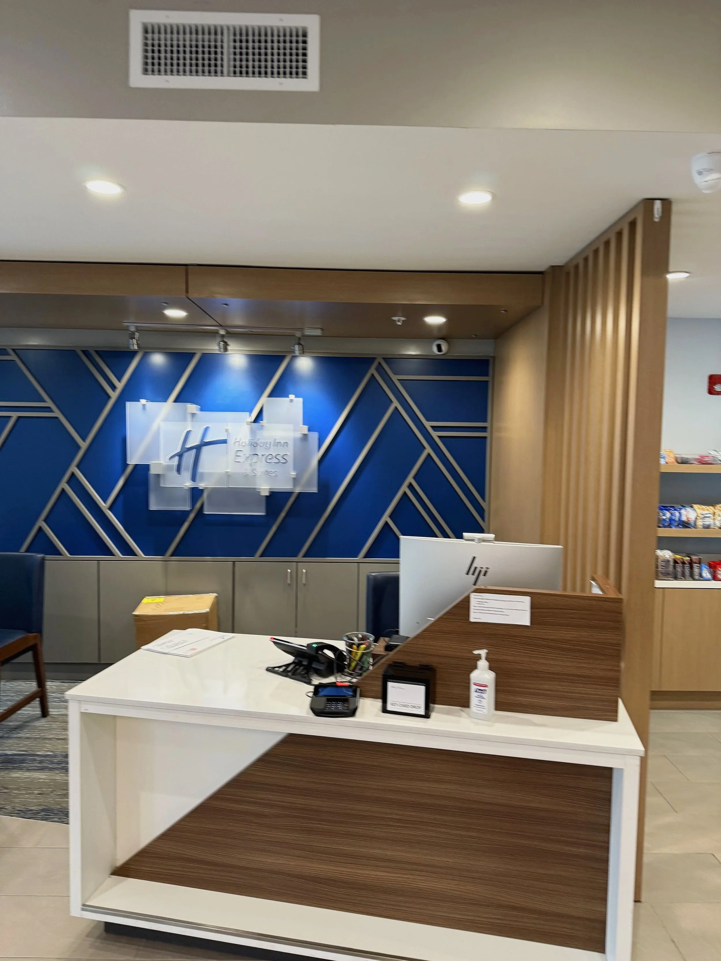 Hotel-style reception desk with blue geometric feature wall and wood accents