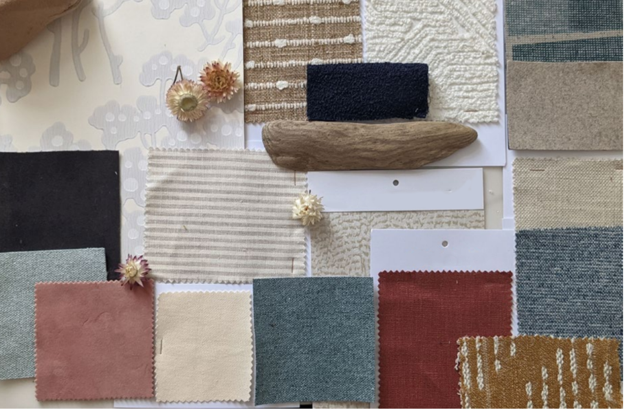 Samples of fabric swatches in various colors and textures, along with small dried flowers and a piece of driftwood on a flat surface.