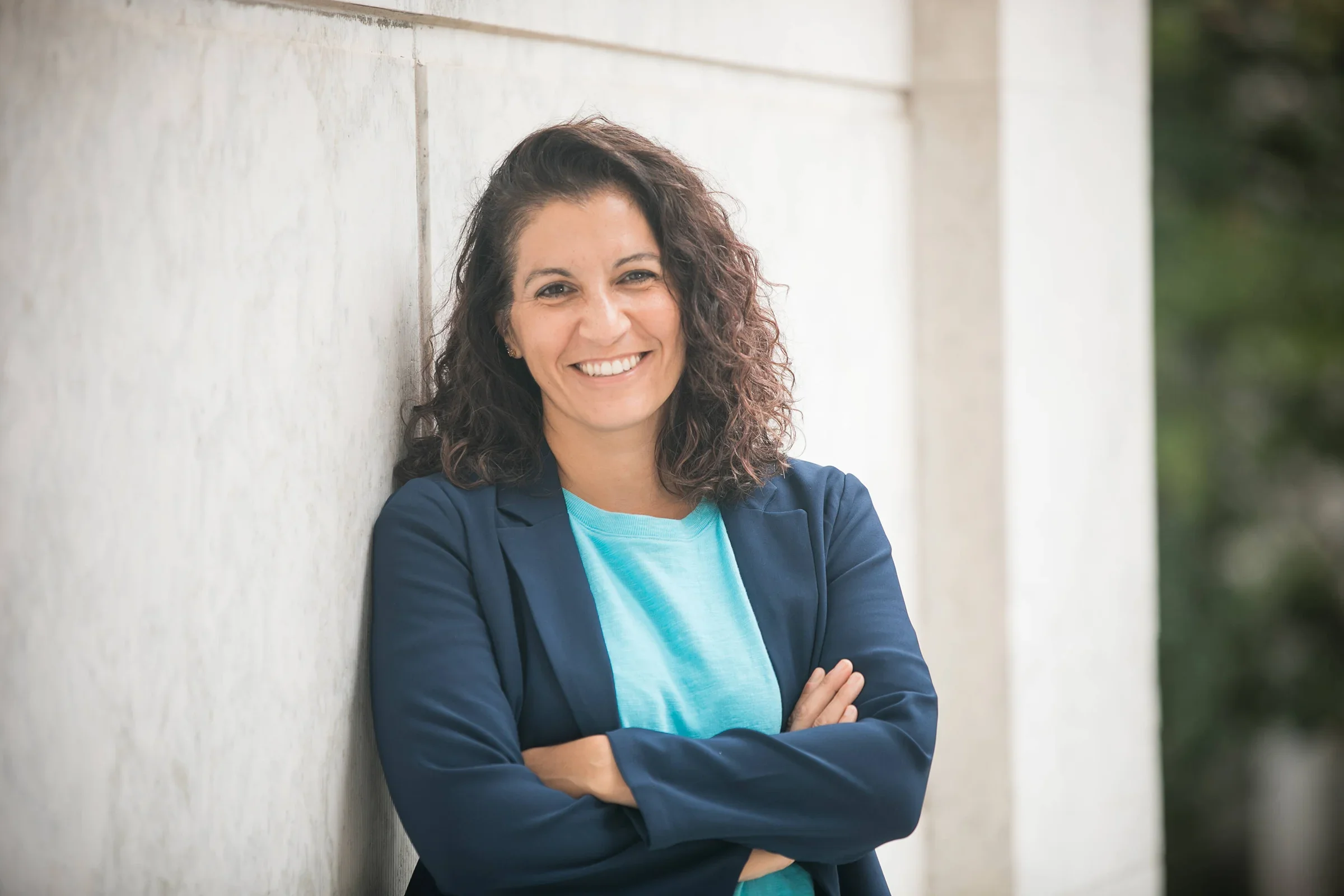 Christine Beck, NJ Certified Resume Writer & Career Coach with curly brown hair, wearing a blue blazer and light blue shirt, smiling with crossed arms outdoors.