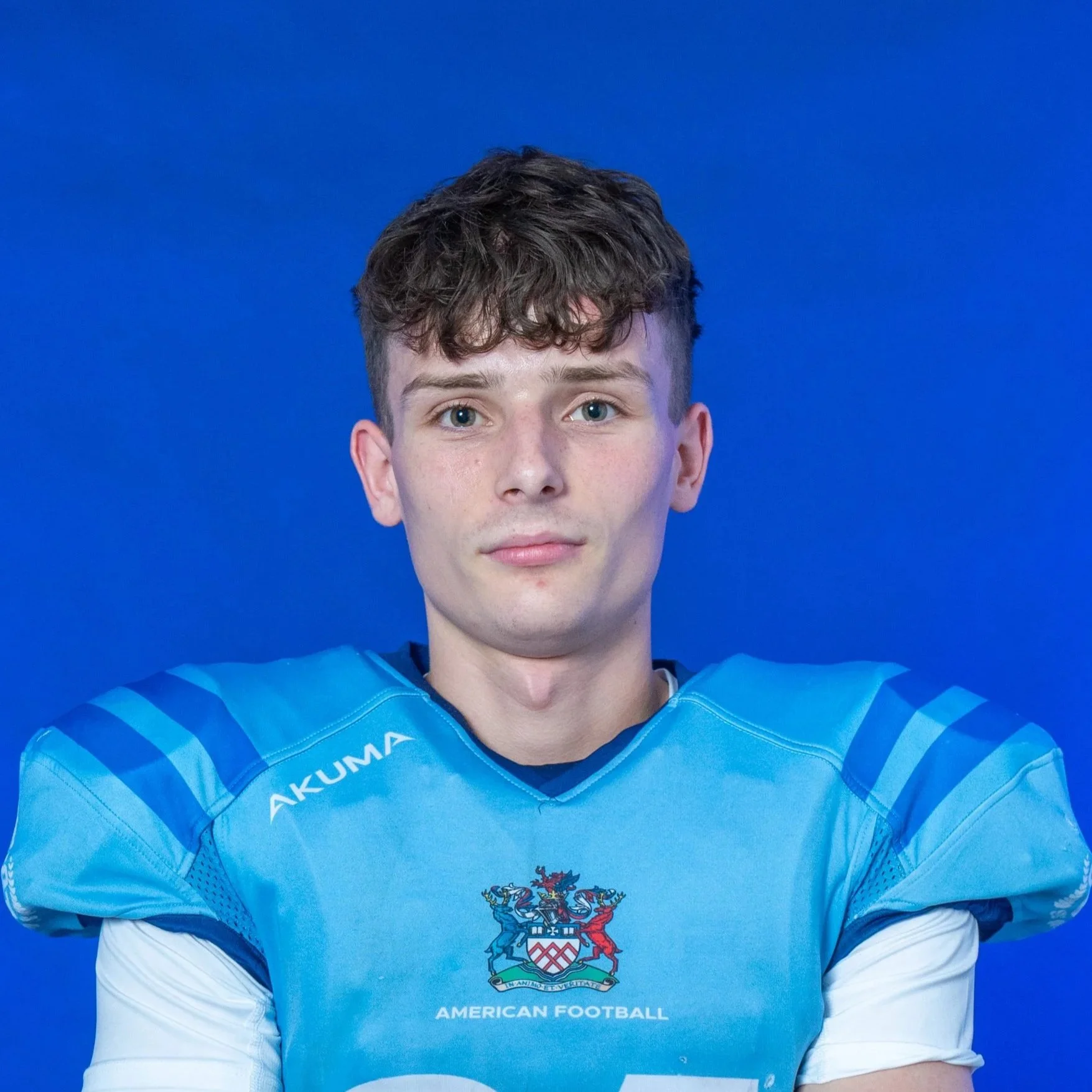 A football player in a light blue GLOVIS jersey and helmet holding a football. The background features the GLOVIS logo and a blue backdrop.