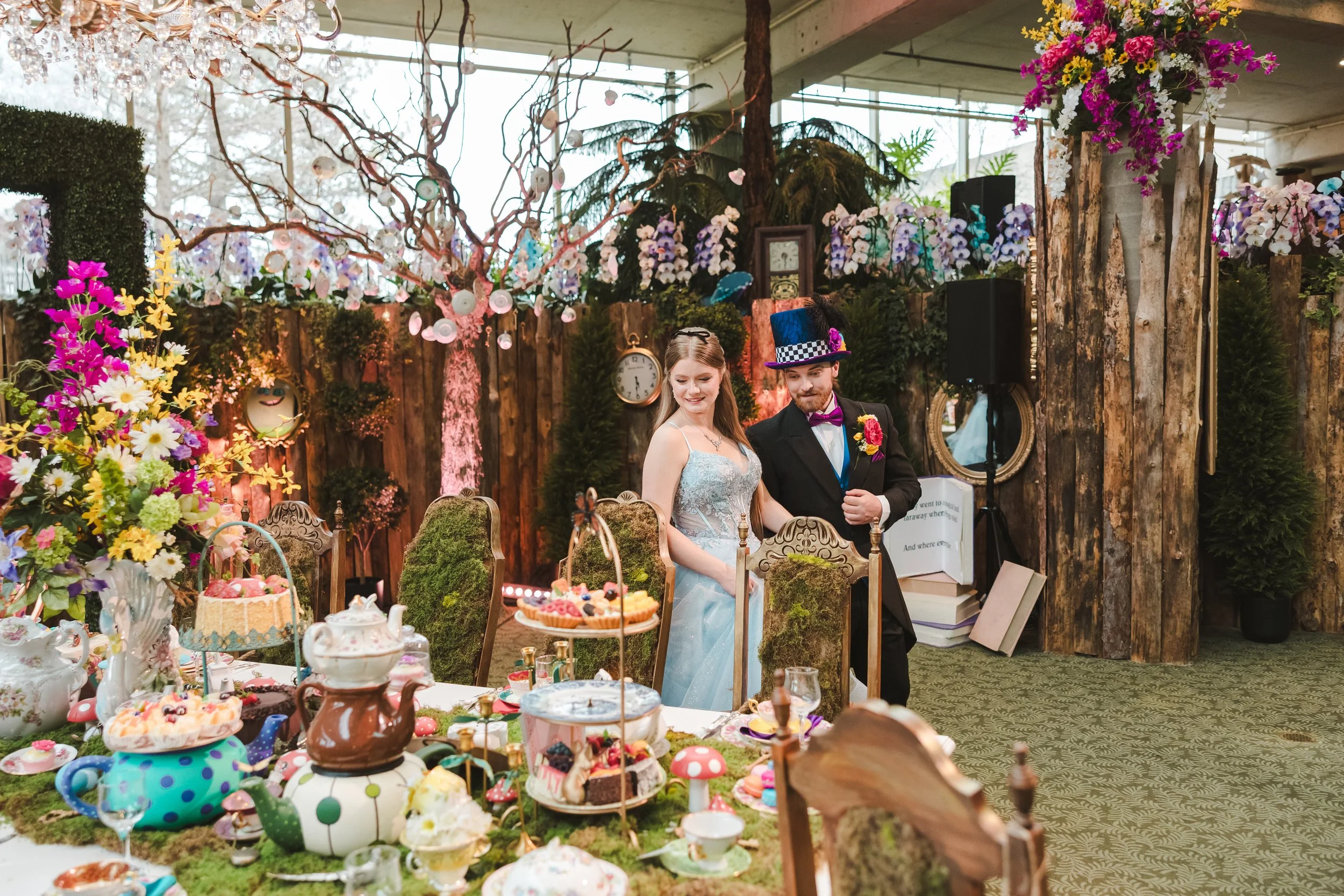 bride-in-blue-and-groom-in-tophat-and-suit-admire-dessert-table-alice-in-bloomland-fedora-media.jpg