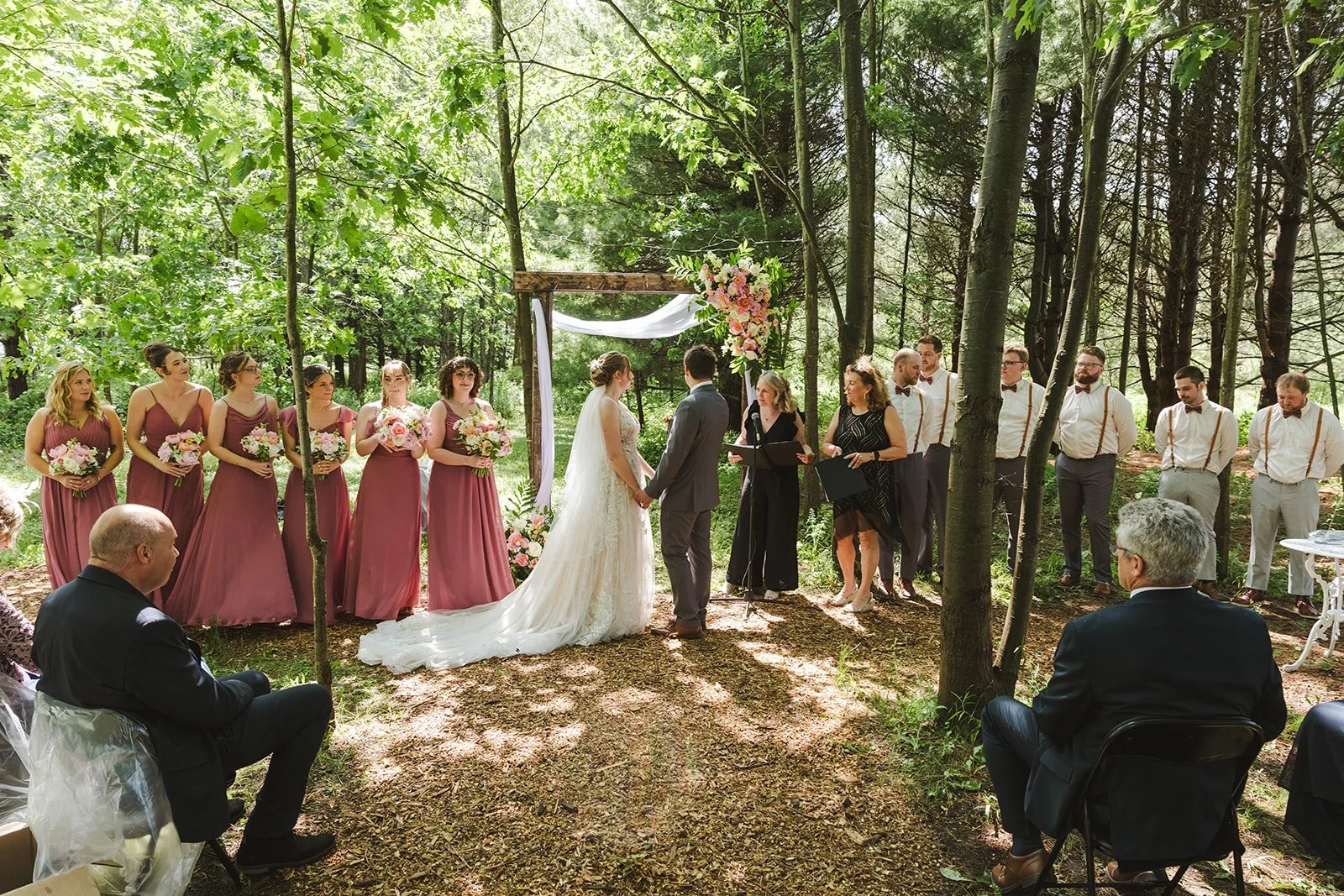 Bride and groom hold hands during wedding ceremony  Boho Wedding  Fedora Media.jpg